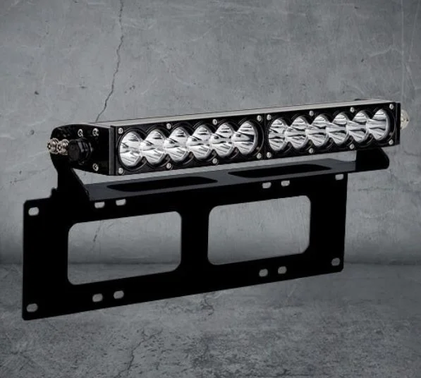 High-powered LED light bar mounted on a black metal bracket against a concrete wall.
